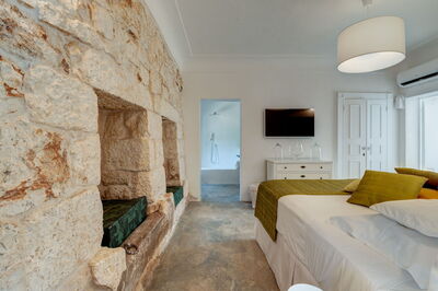 Masseria Isaia, dormitorio con paredes antiguas