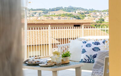 Sopraloreto Apartment: Mueble, Diseño De Interiores, Silla, Mueble Para Exteriores, Balcón, Sombra, Manchas De Madera, Diseño, Planta De Casa, Linos